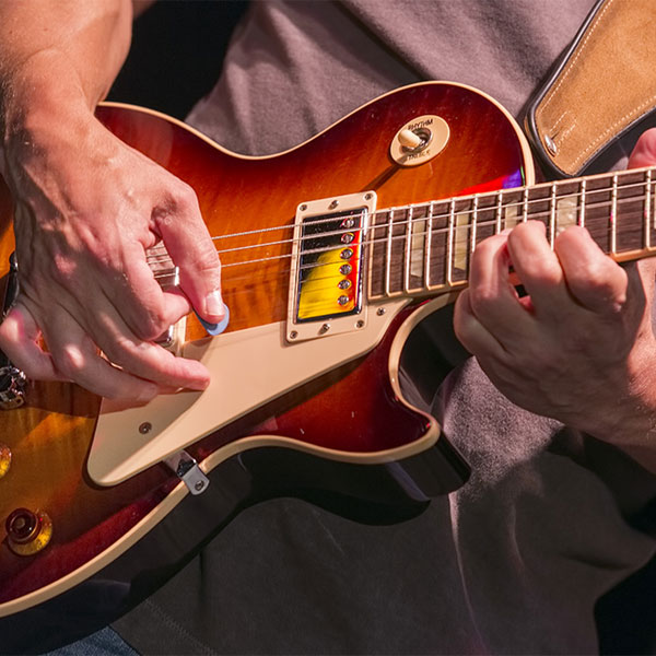 Close up of hands playing a guitar.